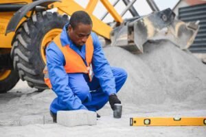 Construction worker installing concrete pavers with precision at a residential job site in Brunswick OH.